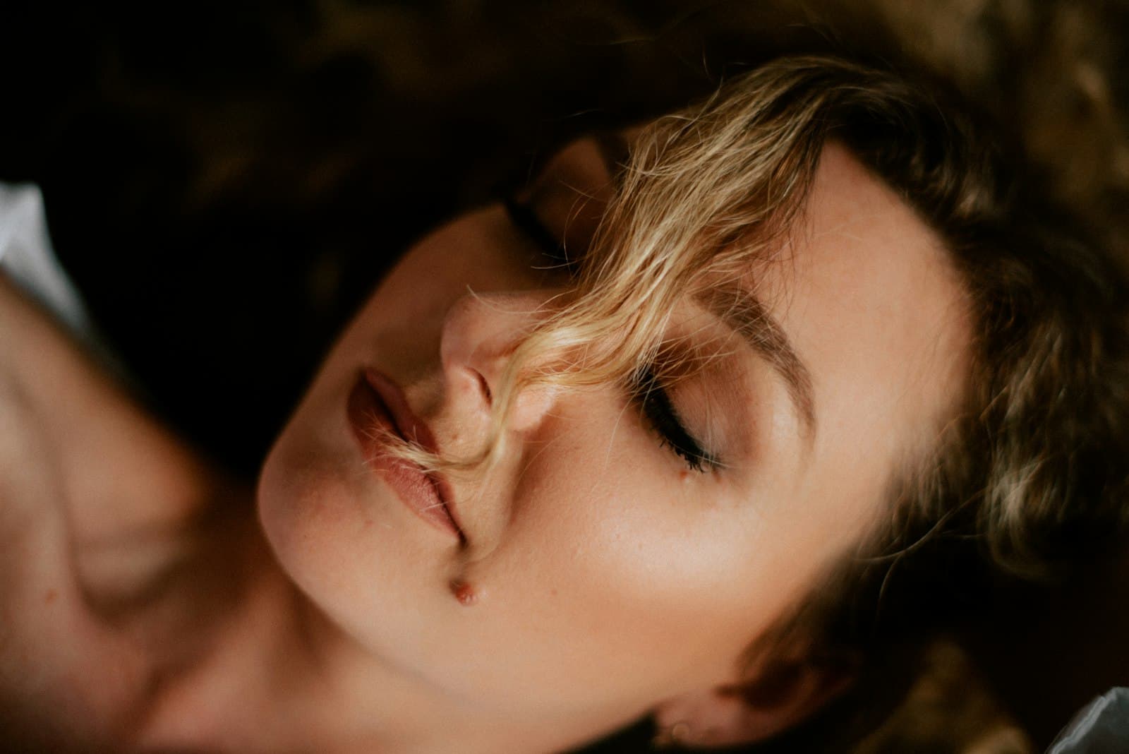 Woman with closed eyes in warm light, before Sunekos in London
